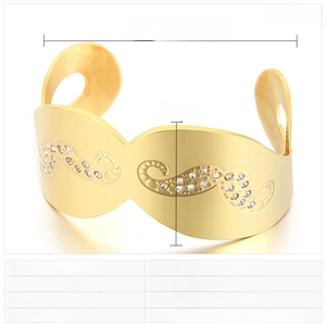 Detail view of gold stainless steel open bangle with wavy textures and rhinestone inlay