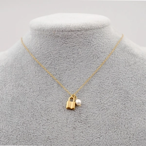 Collier élégant en acier titane doré avec pendentif cadenas cœur et perle sur modèle