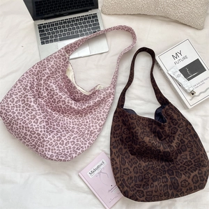 Macro detail of large leopard print tote bags in pink and brown soft suede fabric