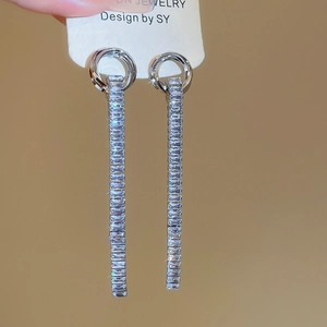 Detail view of silver tassel earrings with rectangular cubic zirconia on jewelry card