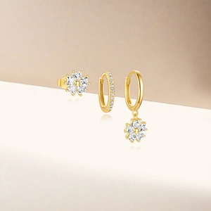 Detail of S925 stamped gold flower earrings set with clear cubic zirconia stones