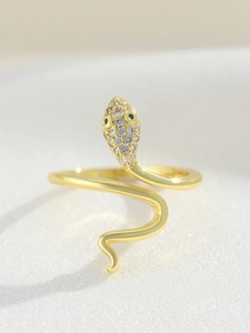 Macro view of gold snake ring featuring micro-paved cubic zirconia and black gemstone eyes