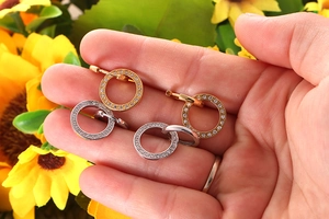 Detail of geometric round earrings with inlaid cubic zirconia in gold and silver