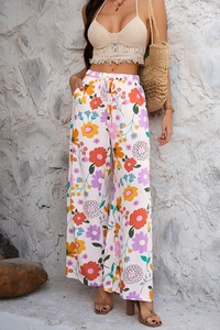 Détail du pantalon large fleuri bohème avec taille élastique et haut court en tricot