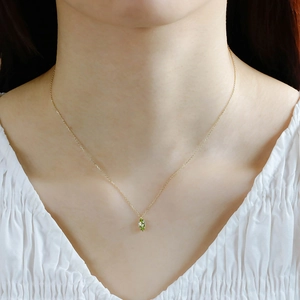 Detail of a vintage-style S925 silver gold chain necklace with a green oval gemstone