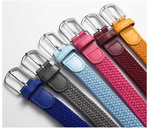Detail view of six multicolored elastic braided belts with metal buckles and leather trim