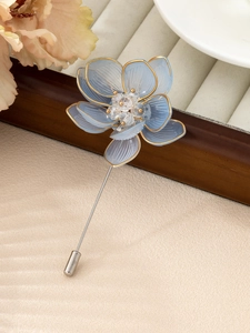 Macro detail of elegant blue flower brooch with gold edges and silver long pin design
