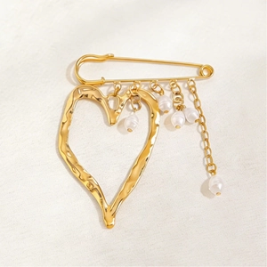 Detail of gold liquid lava heart brooch with pearls and textured irregular metal finish