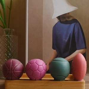 Close-up of four sports ball silicone molds for candles and soap on a wooden base