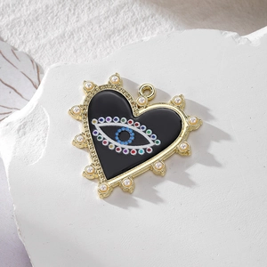 Gold heart evil eye pendant with pearls and colorful beads on a white pedestal