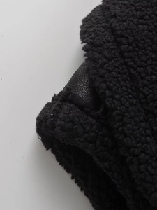 Gros plan sur polaire sherpa noire avec des détails de patchwork en similicuir