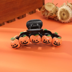 Detailed close-up of spooky orange pumpkin hair clip with wizard hat for Halloween parties