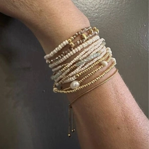 Layered gold bead and freshwater pearl bracelet set for women shown on a wrist