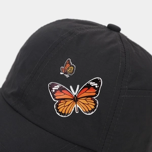 Detailed view of vivid butterfly embroidery on a black quick-dry sports baseball cap