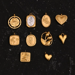 Detailed collection of 18K gold plated embossed sunflower and rose charms on dark surface