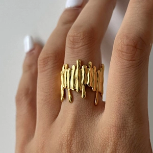 Close-up of golden irregular lava-style ring featuring a liquid metal textured design