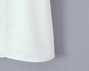 Close-up of the stitched hem and smooth white fabric on this square neck lace mini dress