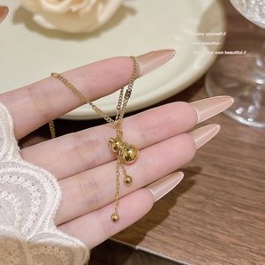 Collier élégant en acier titane doré avec pendentif double perle et glands de chaîne