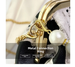 Macro view of gold metal hardware, lobster clasp and white pearls on cow print handbag
