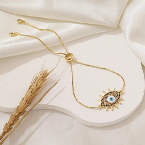 Adjustable gold evil eye bracelet with colorful zircons on an elegant white silk background