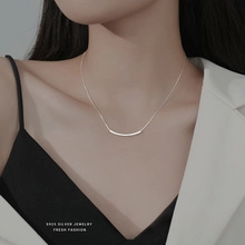 Close-up of a minimalist S925 sterling silver smile-shaped pendant necklace on a model