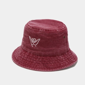 Close-up of burgundy washed cotton bucket hat with white hand embroidery and metal eyelets