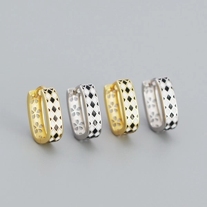 Detail view of U-shaped checkered hoop earrings in gold and silver finish with floral accents