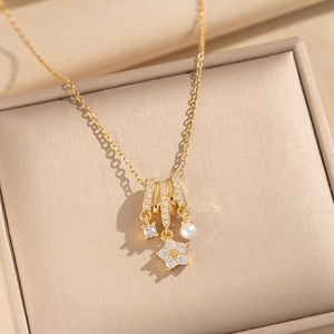 Elegant gold flower pearl necklace with zircon rings displayed on a premium jewelry box