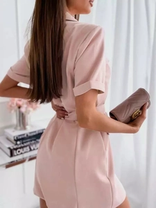 Side view of pale pink short-sleeve blazer dress with belted waist and lapel collar