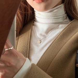 Detail of a minimalist 925 sterling silver square pendant necklace and slim round ring
