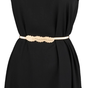 Detail of golden metal spring belt featuring triple leaf buckle on black dress