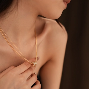 Details einer vergoldeten Schichtkette mit einem zirkonia-besetzten Kugelanhänger