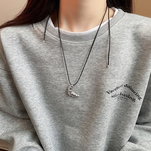 Detail of silver croissant pendant on adjustable black leather cord over a grey hoodie