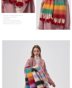 Detail of colorful striped scarf with red pompoms on a pink wool coat collar