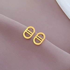 Macro shot of gold-plated pig nose earrings on premium textured fabric background