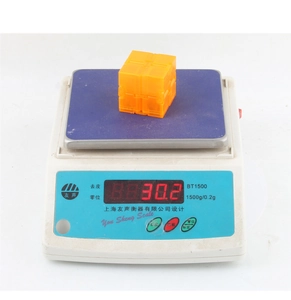 Detail view of a translucent orange infinity cube showing a weight of 30.2g on a scale
