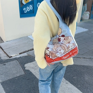 Outdoor shot of the light blue canvas tote bag with cute cartoon dog prints on the back