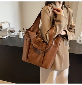 Brown faux leather tote bag styled with a beige blazer for a professional commuter look