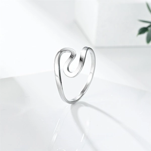 Detailed view of curved silver stainless steel ring with polished wavy design