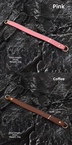 Detail of 22mm wide pink and coffee PU leather bag straps with golden D-rings on rock