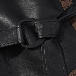 Detail view of black faux leather jacket featuring a round buckle and brown plush lining