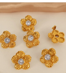 Macro view showing floral gold studs with white zircons and needle back closures