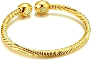 Detail of twisted cable gold bracelet with magnetic spherical ends on white background