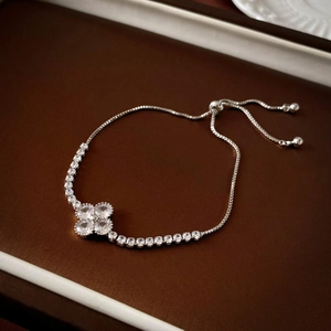 Macro shot of silver adjustable pull-chain bracelet featuring zircon four-petal flower detail
