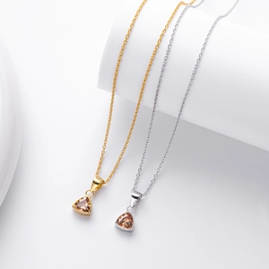 Close-up of geometric S925 silver necklaces with amber triangle pendants on display
