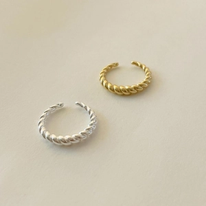 Detail of gold and silver twisted rope rings with polished finish and open adjustable design