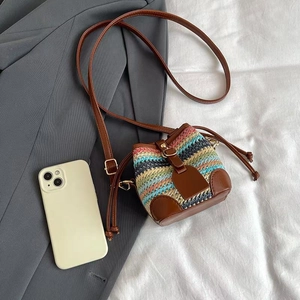 Colorful woven straw bucket bag with brown PU leather straps and drawstring closure