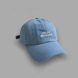 Macro shot of light blue cotton baseball cap with white HELLO WEEKEND embroidery detail