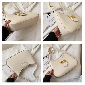 Detail view of cream leather shoulder bag showing gold buckle and sleek curved design