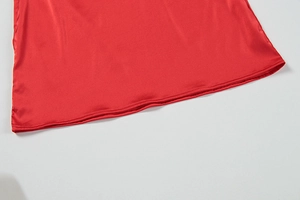 Detailed macro view of the smooth red satin dress hem with professional stitching